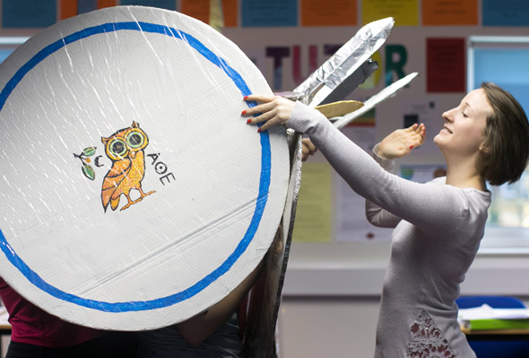 A teacher helps students perfect their shield wall.