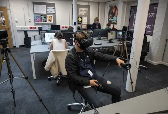 A student using a VR headset in an IT classroom.
