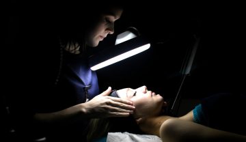 a woman getting a beauty treatment by one of our students in the synergy salon