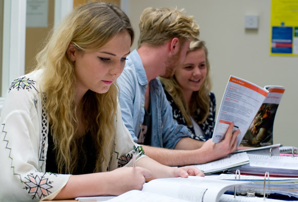 Three students studying with books on their Access to Higher Education course