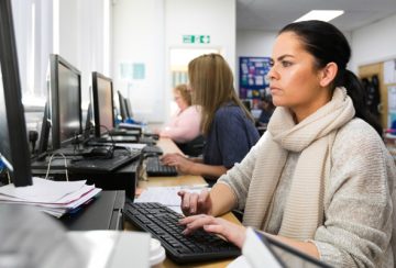 students on their adult learning course typing on computers.