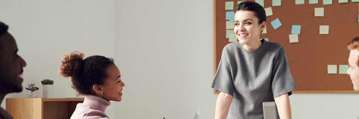 a woman speaking to a team in an office