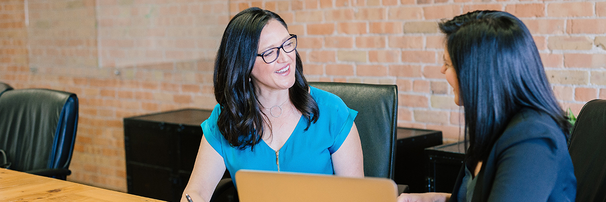 two women having a one to one meeting with a laptop
