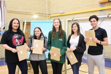 Students holding their A level result