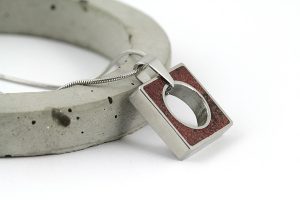 handmade necklace resting on concrete