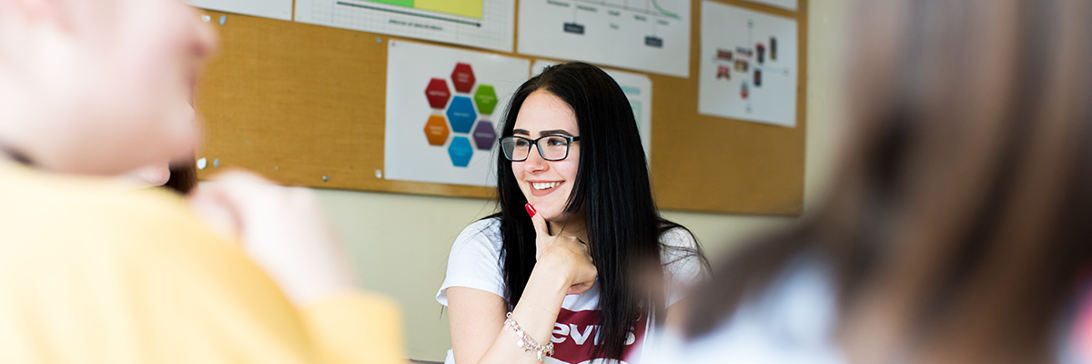 student in a classroom, smiling