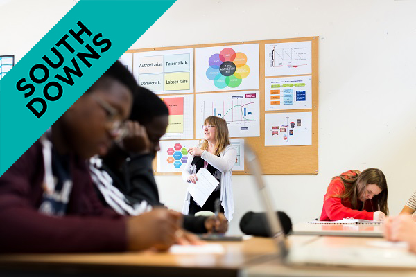 male students in class with teacher in background