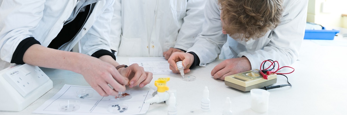 students working with chemicals in lab coats