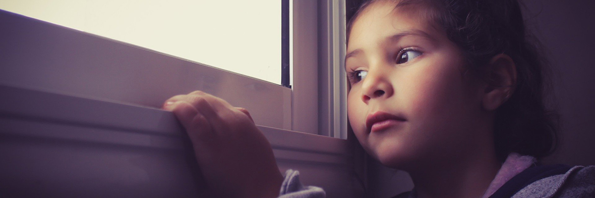 a child looking out of a window in thought