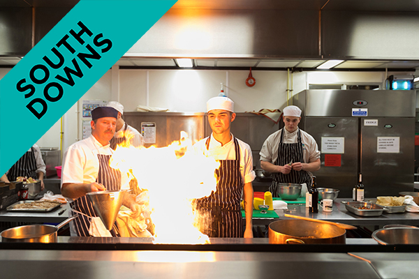 students cooking with fire in college kitchen