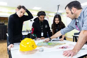 students around a table in with a lecturer