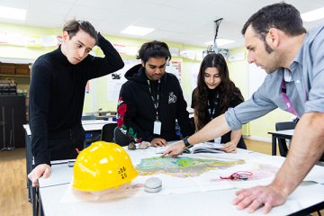 students around a table in with a lecturer