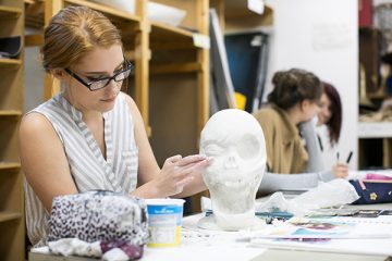 a student working on a clay art piece