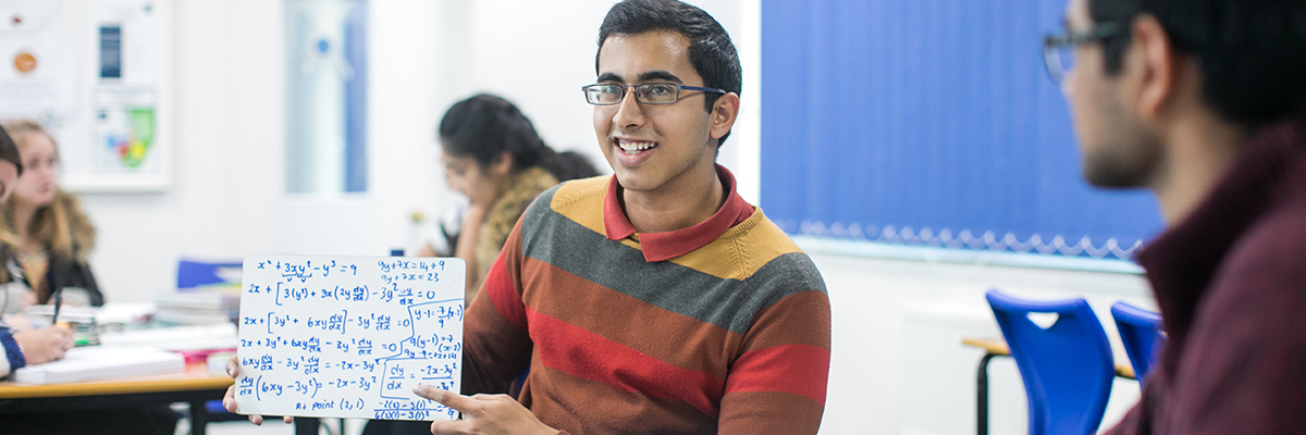 a student holding up math equations