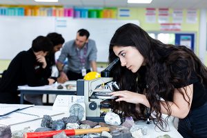 a student looking through a microscope
