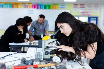 a student looking through a microscope