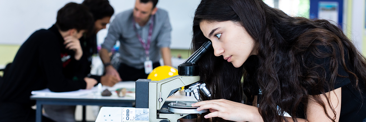 student looking through a microscope