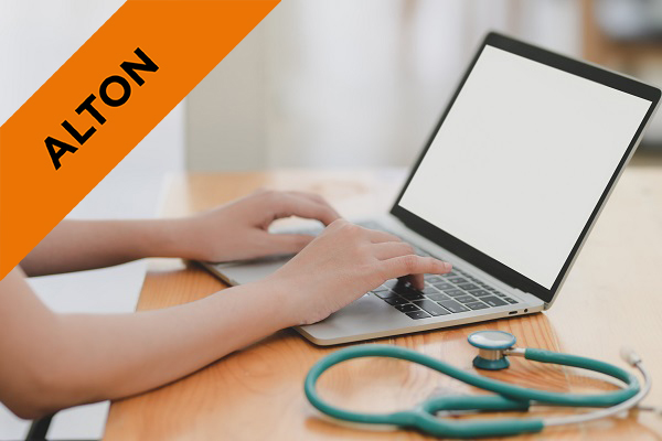 a nurse typing on a laptop with a stethoscope next to them