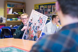 a student holding up a history poster in class
