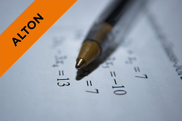 close up of a pen on paper with math sums