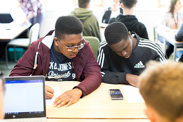 two students working together with a calculator