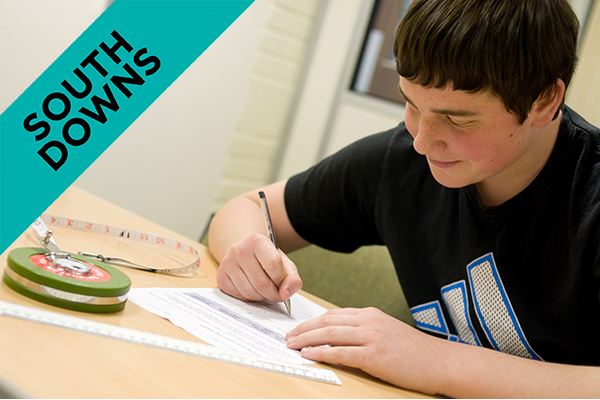 student writing at a desk