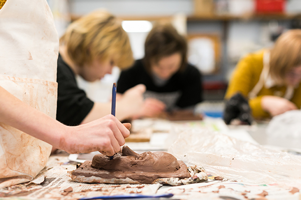 a student working on a clay sculpture