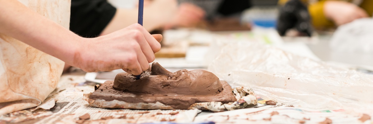 a student working on a clay sculpture