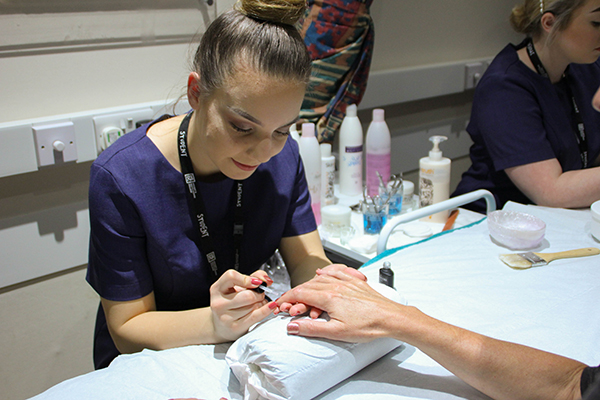 a beauty students giving someone a manicure