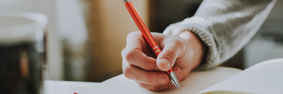 close up of someone holding a pen