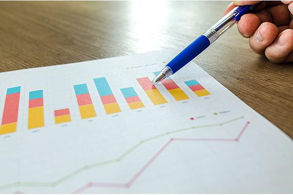 closeup of data charts on a paper with a pen pointing at it