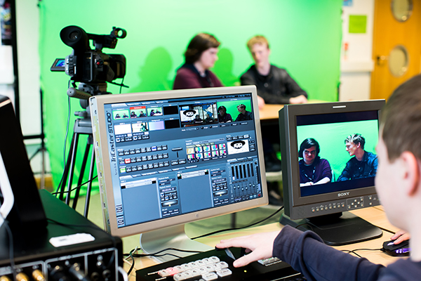 computer screen showing video editing software with a camera and green screen in background