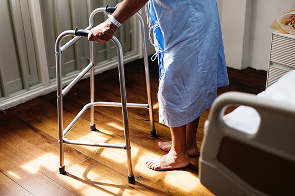 an elderly person using a zimmer frame
