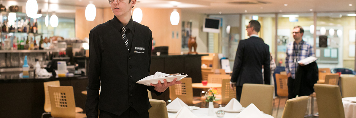 a student serving in the college restaurant