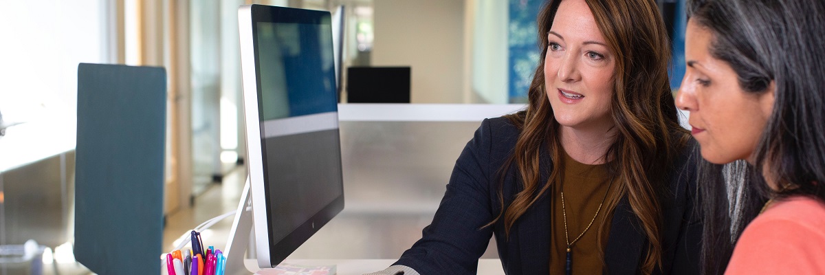 two women collaborating over a laptop