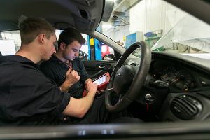 two students in a workshop car