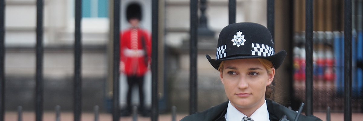 policewoman standing in front of Buckingham palace