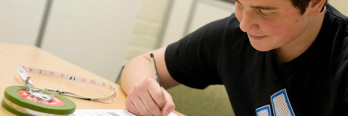 student writing at a desk