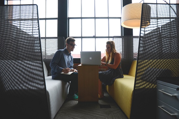 a male and female collaborating over a laptop