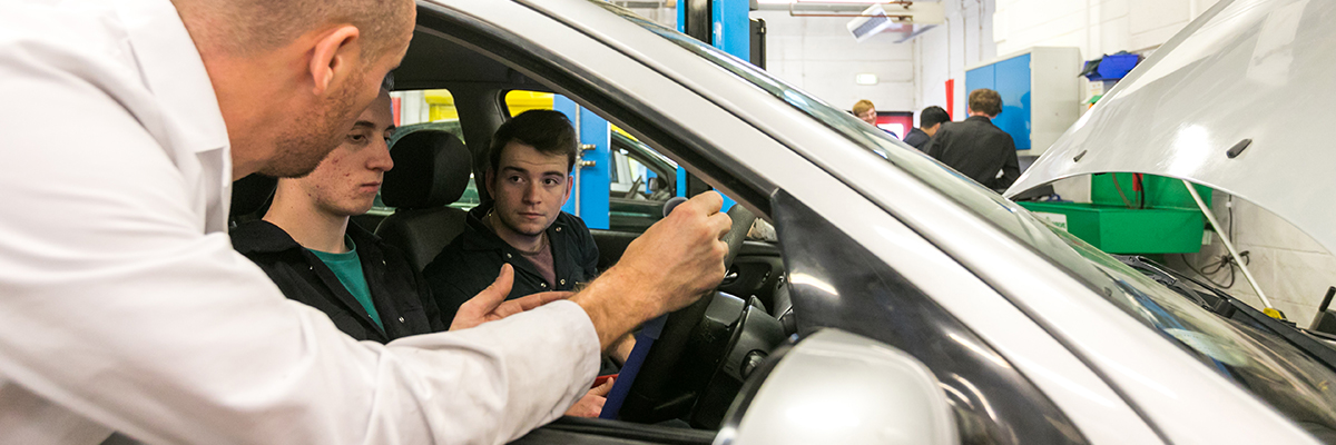 student and lecturer in a car in the college workshop