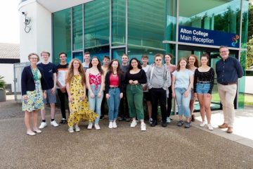 large group of students in front of Alton campus reception with staff members