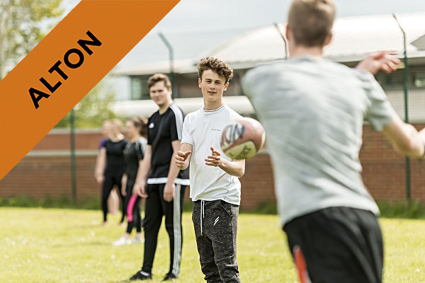 Alton male students playing passing a rugby ball to each other