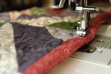 close up of fabric going through a sewing machine