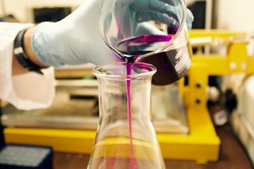 chemicals being poured into a beaker