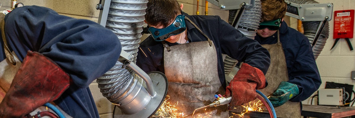 male students working in engineering workshop