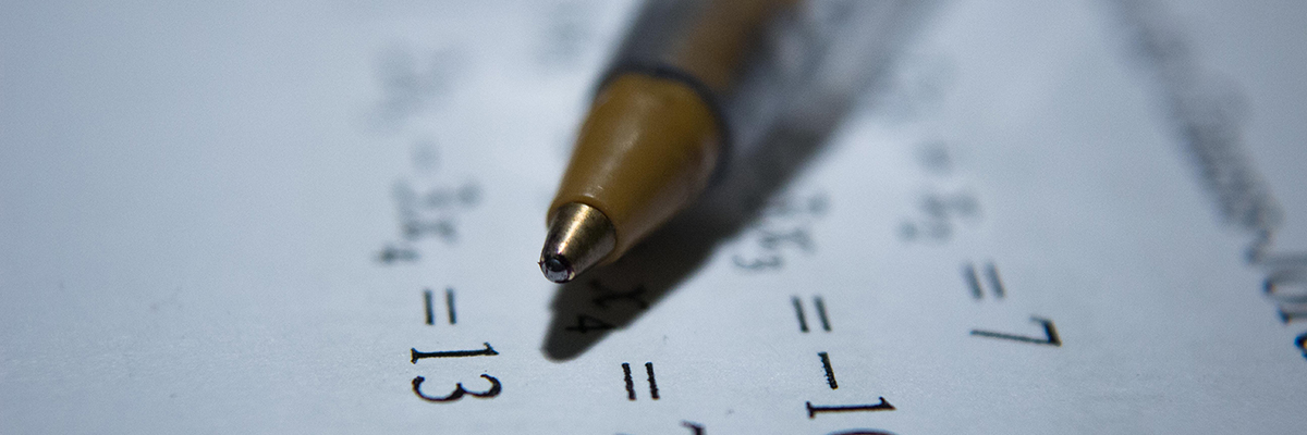 close up of math sums and a pen