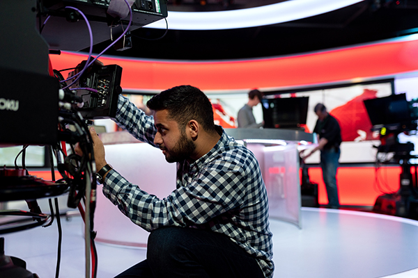 someone handling camera equipment in a TV studio