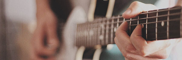 close up of someone playing guitar