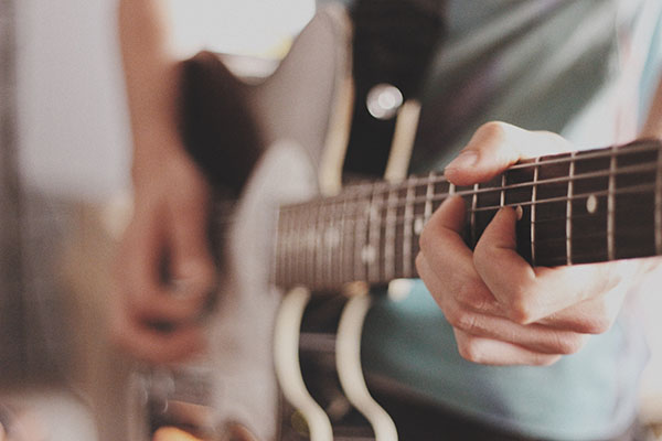 close up of someone playing guitar