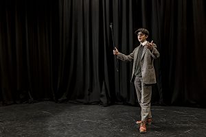 a student performing in a play on stage in costume